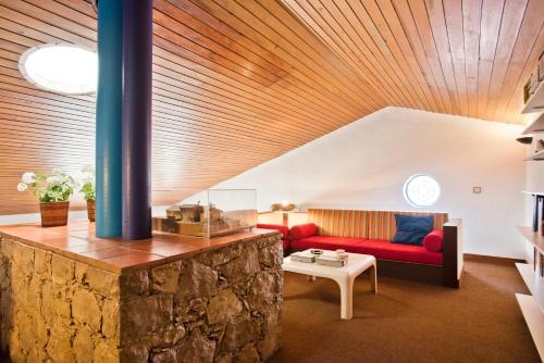 a living room with a red couch and a table at BmyGuest - Sesimbra Country Villa in Sesimbra