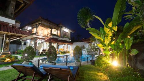 a villa with a swimming pool at night at Mudha Bali Villa Sanur 4 Bedrooms in Sanur