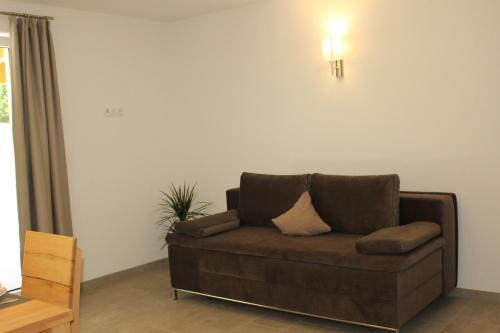 a brown couch sitting in a living room at Apart Alpenjuwel in Sankt Leonhard im Pitztal
