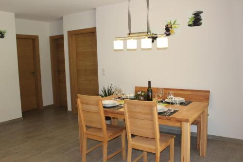 a dining room with a wooden table and chairs at Apart Alpenjuwel in Sankt Leonhard im Pitztal