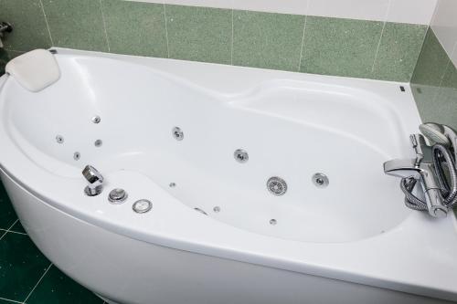 a white bath tub sitting in a bathroom at Penzion Pohoda in Trutnov