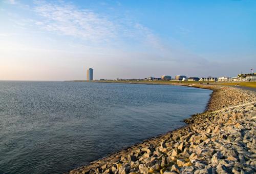 a rocky beach with a building in the background at Bernstein-Hotel Bootshaus in Büsum