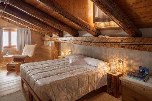 Un dormitorio con una cama grande en una habitación con techos de madera. en Albergo Pa' Krhaizar, en Sauris