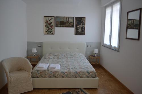 a bedroom with a bed and a chair and a window at La Scala Rho B&B in Rho