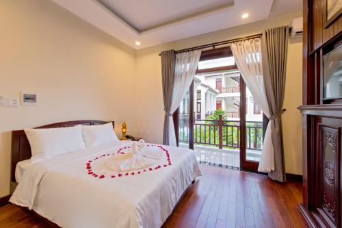 Un dormitorio con una cama y una ventana grande. en Green Hill Villa, en Hoi An