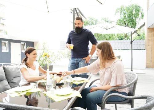 Un groupe de personnes assises autour d'une table dans l'établissement CREO Munich City, à Munich