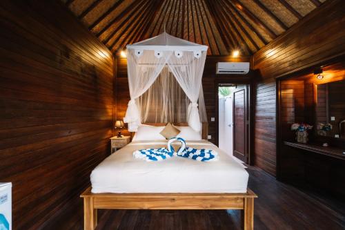 a bedroom with a white bed with a canopy at Dodol Lembongan Cliff Sunset in Nusa Lembongan
