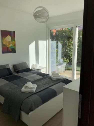 a bedroom with a large bed and a large window at Roggia Apartments by Quokka 360 - central flats with parking space in Lugano