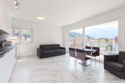 a kitchen and dining room with a table and chairs at Roggia Apartments by Quokka 360 - central flats with parking space in Lugano