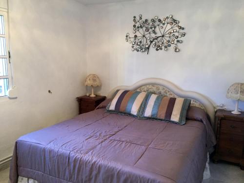 アリアテにあるVilla Oasisのベッドルーム1室(紫色のベッド1台、ナイトスタンド2台付)