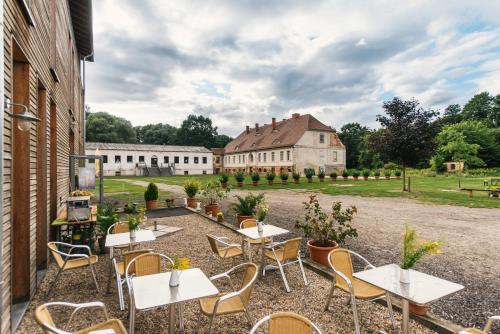 eine Terrasse mit Tischen und Stühlen und ein Gebäude in der Unterkunft Gästehaus am Landgut in Schönwalde