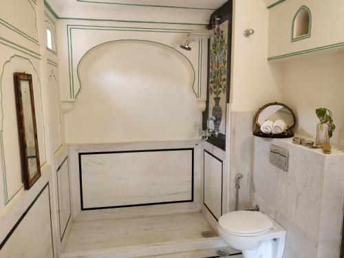 a bathroom with a white toilet in a room at Jaipur Haveli in Jaipur
