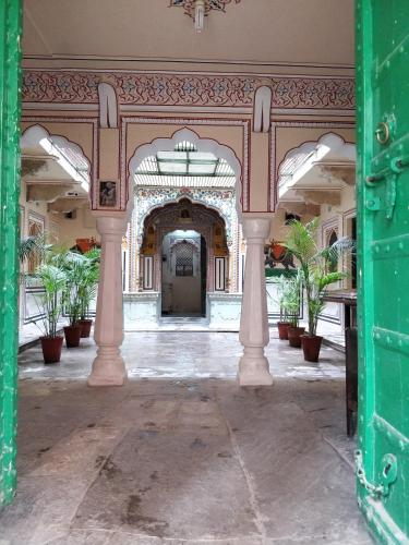 an open doorway to a building with potted plants at Jaipur Haveli in Jaipur