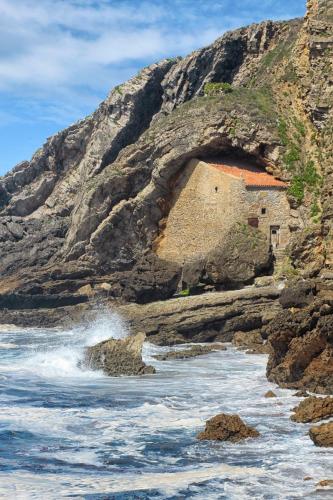 a building on the side of a rocky beach at Apartamentos Costa Esmeralda in Suances
