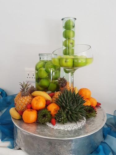 a plate of fruit with a glass of apples and oranges at Van Dykshuis Guest House in Heidelberg