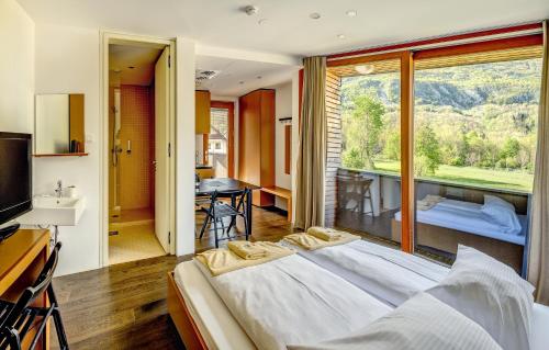 ein Schlafzimmer mit einem großen Bett und einem großen Fenster in der Unterkunft Hotel Sanje ob Soči ***/**** in Bovec
