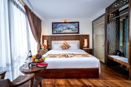 a bedroom with a bed and a table with a bowl of fruit at Sapa Relax Hotel & Spa in Sa Pa