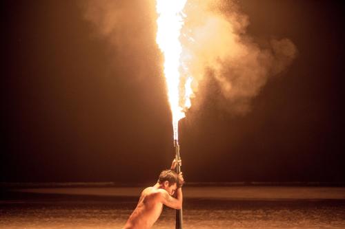 a man holding a pole with fire in the air at Bhu Tarn Koh Chang Resort & Spa in Ko Chang