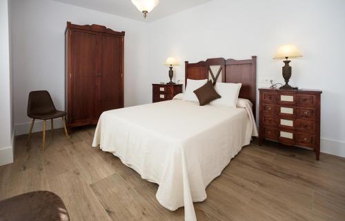 モンテフリオにあるNuevo Montefturのベッドルーム(白い大型ベッド1台、木製家具付)