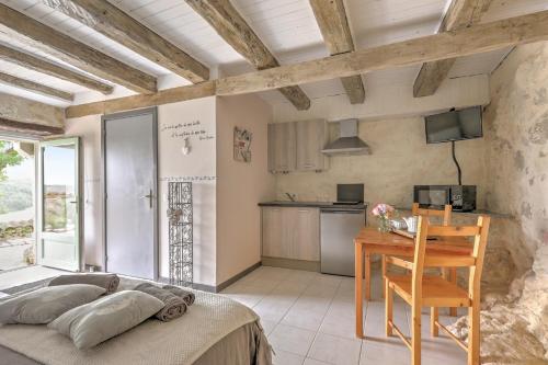 a living room with a table and a kitchen at Maison de vacances Le Mas des papillons in Fargues