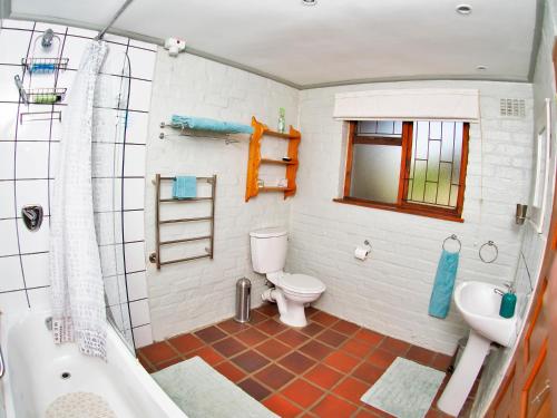 a bathroom with a toilet and a sink and a tub at Elly's Place B&B in Darling