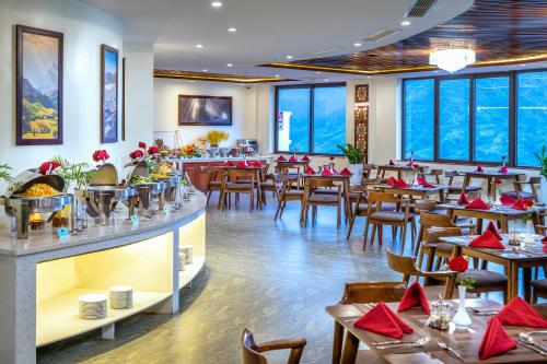 a restaurant with tables and chairs and windows at Sapa Relax Hotel & Spa in Sa Pa