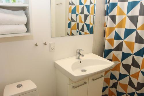 a bathroom with a sink and a mirror and a toilet at Hotel Nysted Havn in Nysted