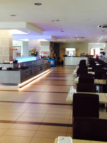 a restaurant with rows of chairs and a waiting room at Grand Court Hotel in Teluk Intan