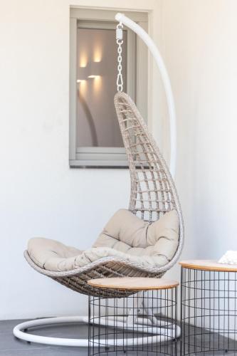 a rattan chair with a cushion in front of a mirror at Aegean Gem in Kamari