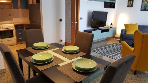 a dining room with a table and chairs and a television at Apartment Dora in Rijeka
