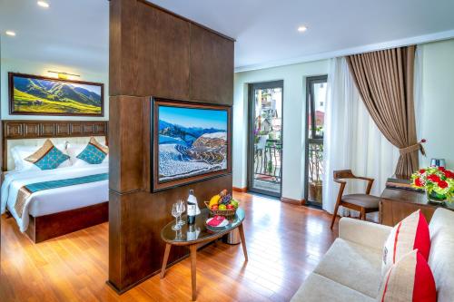 a hotel room with a bed and a table at Sapa Relax Hotel & Spa in Sa Pa