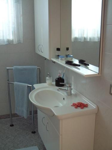 a white bathroom with a sink and a mirror at Residence Hofer in Valdaora