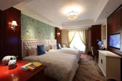 a hotel room with two beds and a television at S&N Zhejiang LinHai International Hotel in Linhai
