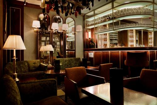 a restaurant with chairs and tables and a bar at The Stafford London in London