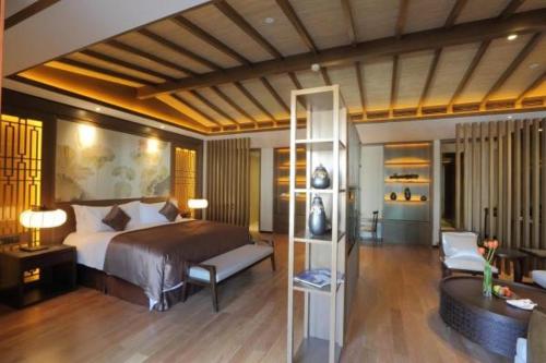a bedroom with a bed and a living room at S&N Zhejiang LinHai International Hotel in Linhai