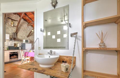 uma casa de banho com um lavatório e um espelho em Le Mas Des Papillons chambre d'hôtes B&B em Fargues