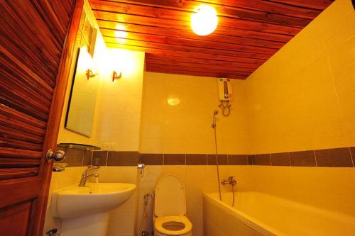 a bathroom with a sink and a toilet and a tub at Sathorn Saint View Serviced Apartment in Bangkok