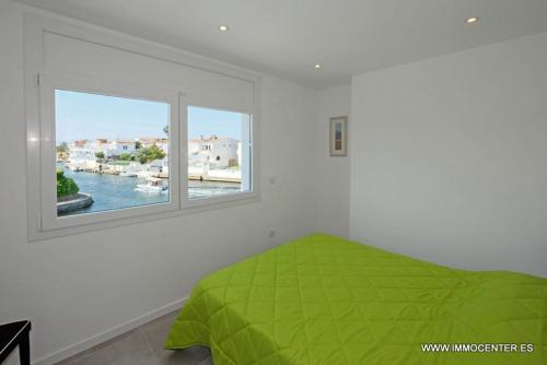 Un dormitorio con una cama verde y una ventana en LV04, en Empuriabrava