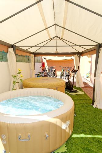 a tent with two beds and a hot tub at Residence La Corte Di Anastasia in Torpè