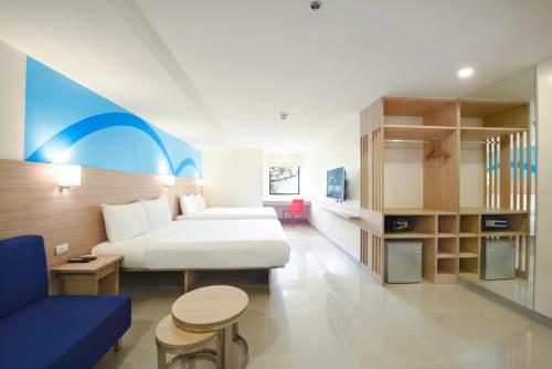 a hotel room with a bed and a couch and a table at Hop Inn Hotel Alabang Manila in Manila