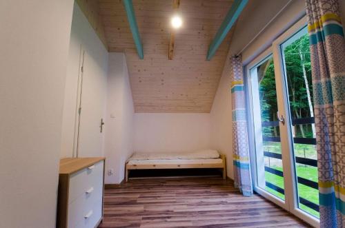 NadoleにあるLeśne Zacisze w Nadoluのベンチと窓付きの小さな客室です。