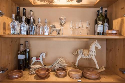 a shelf with bottles and glasses and a horse on it at Hotel Koníček in Uherské Hradiště