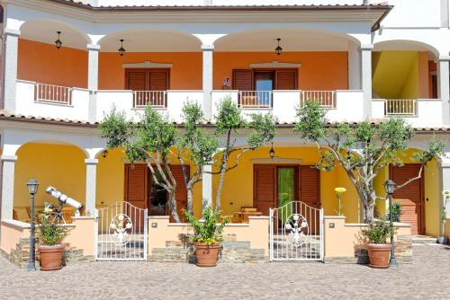 a building with trees in front of it at Residence La Corte Di Anastasia in Torpè