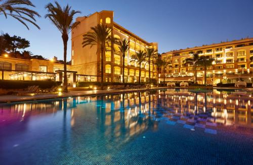 
a large swimming pool with a large clock tower in the middle of it at Insotel Fenicia Prestige Suites & Spa in Santa Eularia des Riu
