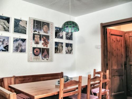 uma sala de jantar com mesa e cadeiras e quadros na parede em Apartment "La maison des Guides" em Courmayeur