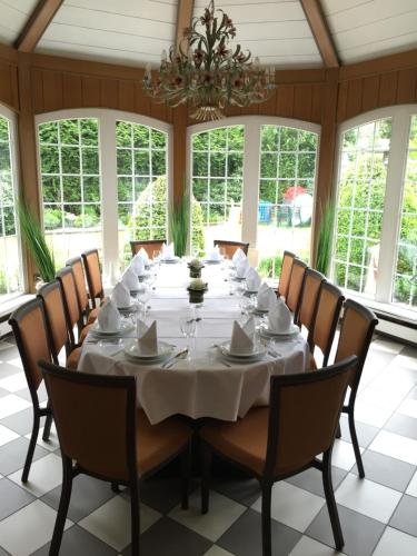 een grote eetkamer met een witte tafel en stoelen bij Holskenbänd in Horstmar