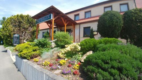 a flower garden in front of a building at Hotel-Restaurant Elsterblick in Elsteraue