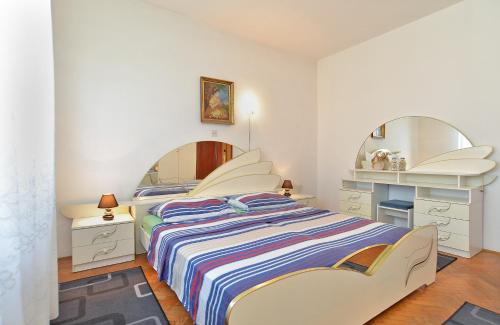 sypialnia z łóżkiem i dużym lustrem w obiekcie Apartments Gracijano 1724 w mieście Ližnjan