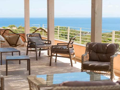 balcone con sedie, tavoli e vista sull'oceano di Park Hotel Asinara a Stintino