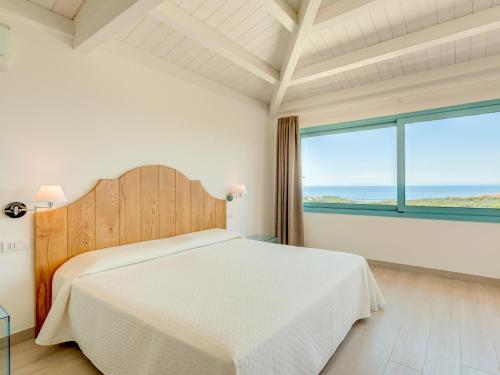 a bedroom with a bed and a large window at Park Hotel Asinara in Stintino